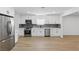 Bright kitchen featuring white cabinets, stainless steel appliances, light wood flooring, and modern finishes at 613 Kings Pl, Boulder City, NV 89005
