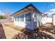 Back exterior featuring a spacious yard, a white exterior, a small patio, and multiple windows at 613 Kings Pl, Boulder City, NV 89005