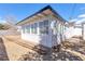 Back exterior featuring a spacious yard, a white exterior, a small patio, and multiple windows at 613 Kings Pl, Boulder City, NV 89005