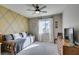 Inviting bedroom with a rustic daybed, ceiling fan, and a sunlit window at 6470 Crest Estates St, Las Vegas, NV 89131