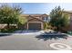 Beautiful two-story home with a three-car garage, stone accents and mature trees enhancing curb appeal at 6470 Crest Estates St, Las Vegas, NV 89131