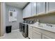 Well-equipped laundry room with modern appliances, sink, and ample storage at 6470 Crest Estates St, Las Vegas, NV 89131