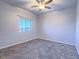 Neutral bedroom boasts a ceiling fan and a window with a neighborhood view at 6709 Barrington Hills St, Las Vegas, NV 89149