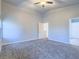 Bright bedroom with neutral carpet, ceiling fan, and an adjoining door at 6709 Barrington Hills St, Las Vegas, NV 89149