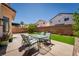 Backyard patio featuring an outdoor dining set and artificial grass at 6973 Pacific Coast St, Las Vegas, NV 89148