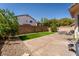 The backyard has artificial turf, a large concrete patio, and a brick wall with string lights for outdoor entertaining at 6973 Pacific Coast St, Las Vegas, NV 89148