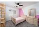 Cozy bedroom featuring a ceiling fan, neutral colors, and ample natural light from a window at 6973 Pacific Coast St, Las Vegas, NV 89148