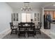 Dining area featuring dark wood table, stylish chandelier, and adjacent stainless steel appliances at 6973 Pacific Coast St, Las Vegas, NV 89148