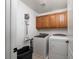 Functional laundry room with cabinetry, appliances, and space-saving vacuum storage at 6973 Pacific Coast St, Las Vegas, NV 89148