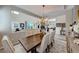 Elegant dining room featuring a modern chandelier and views into the living room and kitchen at 7 Hilltop Crest St, Henderson, NV 89011