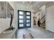 Elegant foyer featuring a modern front door, neutral tile flooring, and a staircase at 7 Hilltop Crest St, Henderson, NV 89011