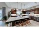 Gourmet kitchen featuring dark cabinets, a large island with bar seating, and modern pendant lighting at 7 Hilltop Crest St, Henderson, NV 89011