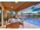 Luxurious covered patio featuring a table, spiral staircase, and an inviting pool with a picturesque sunset view at 7 Hilltop Crest St, Henderson, NV 89011