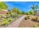 Serene walking path lined with lush greenery and natural stone accents provides a tranquil outdoor experience at 7 Hilltop Crest St, Henderson, NV 89011