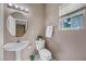 Cozy bathroom features a sleek pedestal sink, toilet, and bright natural light at 7460 Grassy Field Ct, Las Vegas, NV 89131