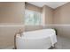 Beautiful bathroom featuring modern standalone tub and neutral tile decor at 7460 Grassy Field Ct, Las Vegas, NV 89131