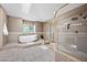 Spacious bathroom featuring soaking tub, a separate glass shower and tile decor at 7460 Grassy Field Ct, Las Vegas, NV 89131
