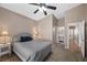 This is a cozy bedroom featuring neutral walls, carpet, ceiling fan and an ensuite bathroom at 7460 Grassy Field Ct, Las Vegas, NV 89131