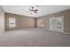 Large bedroom featuring carpet, a ceiling fan, and access to a private balcony through glass paneled doors at 7460 Grassy Field Ct, Las Vegas, NV 89131