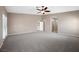 Spacious carpeted bedroom featuring a ceiling fan and access to an open doorway at 7460 Grassy Field Ct, Las Vegas, NV 89131