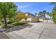 Two-story home with solar panels and three-car garage, nestled among lush trees and landscaped yard at 7460 Grassy Field Ct, Las Vegas, NV 89131