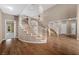 Elegant foyer features a grand staircase with white railings and wood floors at 7460 Grassy Field Ct, Las Vegas, NV 89131