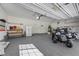 Spacious three-car garage, featuring overhead storage, well-lit interiors, and a motorcycle at 7460 Grassy Field Ct, Las Vegas, NV 89131
