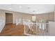 A view of the second story hallway from the stairs with a decorative light fixture and hardwood floors at 7460 Grassy Field Ct, Las Vegas, NV 89131