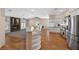Bright open concept kitchen featuring stainless steel appliances, granite countertops, and a stone fireplace at 7460 Grassy Field Ct, Las Vegas, NV 89131