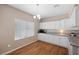 Bright kitchen with white cabinets, granite countertops, and hardwood flooring offers a clean, modern look at 7460 Grassy Field Ct, Las Vegas, NV 89131