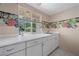 Bright laundry room featuring white cabinets, counter space, and a scenic window view at 7460 Grassy Field Ct, Las Vegas, NV 89131