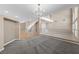 Open-concept living area with modern gray carpet and grand staircase access at 7460 Grassy Field Ct, Las Vegas, NV 89131