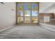 Bright living room with large windows, high ceilings, and neutral carpet at 7460 Grassy Field Ct, Las Vegas, NV 89131