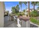 Entertainer's dream outdoor kitchen featuring a built-in grill, sink, fridge, and counter space near the pool at 7460 Grassy Field Ct, Las Vegas, NV 89131