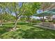 Scenic park with picnic tables, shade trees, and a glimpse of the tennis court in the background at 7460 Grassy Field Ct, Las Vegas, NV 89131