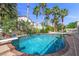 Inviting backyard pool surrounded by lush greenery and mature palm trees, perfect for relaxation and recreation at 7460 Grassy Field Ct, Las Vegas, NV 89131