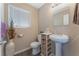 Clean bathroom featuring a pedestal sink, toilet, and decorative storage at 7912 Painted Rock Ln, Las Vegas, NV 89149