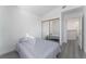 A sunlit bedroom with grey floors, a sliding closet, and a bed at 7912 Painted Rock Ln, Las Vegas, NV 89149