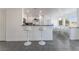 Bright open kitchenette featuring white bar seating, and views to the dining area and exterior at 7912 Painted Rock Ln, Las Vegas, NV 89149