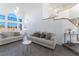 Bright living room featuring modern lighting, couches, and neutral decor with stairs at 7912 Painted Rock Ln, Las Vegas, NV 89149