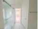 Clean bathroom with glass enclosed shower, double door access, and marble tiled walls at 8223 Buffalo Ranch Ave, Las Vegas, NV 89147