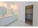 Bright bathroom with double sinks, white cabinets, modern fixtures, and walk in closet access at 8223 Buffalo Ranch Ave, Las Vegas, NV 89147