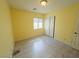 Cheerful yellow bedroom with wood-look flooring, closet with sliding doors, and a bright window at 8223 Buffalo Ranch Ave, Las Vegas, NV 89147