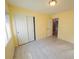 Bright bedroom with light gray wood-look floors, fresh yellow paint, and sliding closet doors at 8223 Buffalo Ranch Ave, Las Vegas, NV 89147