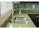 Close-up of a stainless steel kitchen sink with granite countertops and modern faucet fixtures at 8223 Buffalo Ranch Ave, Las Vegas, NV 89147