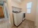 Convenient laundry room with modern washer and dryer, tiled floors, and storage shelving at 8223 Buffalo Ranch Ave, Las Vegas, NV 89147