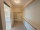Walk-in closet with white shelves, wood racks, and light wood floors at 8223 Buffalo Ranch Ave, Las Vegas, NV 89147