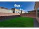 The backyard has an outdoor living space with artificial grass and a brick wall at 8276 Sorrel St, Las Vegas, NV 89139