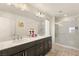 Bathroom featuring double sinks, a large mirror, and a glass-enclosed shower at 8276 Sorrel St, Las Vegas, NV 89139