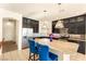 Bright kitchen with a granite island, dark cabinets, stainless steel appliances, and tiled flooring at 8276 Sorrel St, Las Vegas, NV 89139